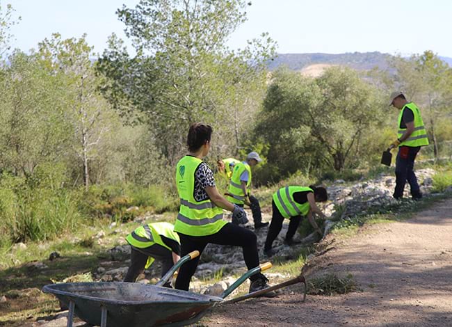 Els voluntaris, treballant a la part exterior del conjunt monumental. Autor: Cercle de Voluntaris dels Parcs Naturals